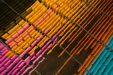 Aerial view of a person working in a public laundry hanging for drying colourful cloth in Narayanganj, Dhaka, Bangladesh. - AAEF10714