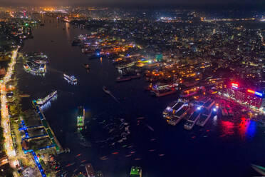 Aerial view of Buriganga river and the Sadarghat Terminal at night with several ships docked with Old Dhaka district in background, Dhaka, Bangladesh. - AAEF10754