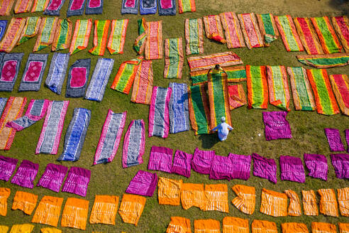 Aerial view of people working in a public laundry draining and drying colourful clothes at sunlight, Araihazar, Dhaka province, Bangladesh. - AAEF10837