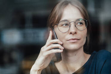 Female professional with brown hair talking on smart phone in cafe - JOSEF05261