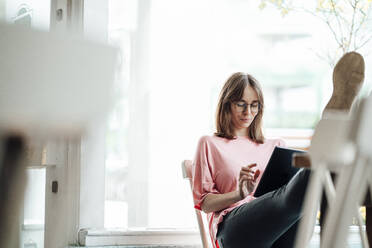 Female professional working while using digital tablet in cafe - JOSEF05282