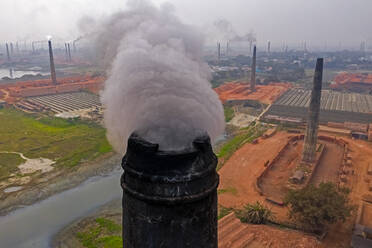 Aerial view of chimneys kilns from brick factory surrounding the area along Dhaleshwari river near Keraniganj township, Dhaka, Bangladesh. - AAEF11001