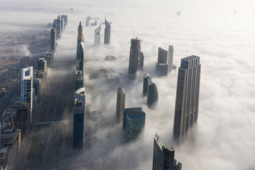 Aerial view of misty skyscrapers with highway in Dubai, United Arab Emirates. - AAEF11189