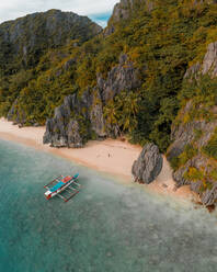 Luftaufnahme eines Ausleger-Fischerboots am Sandstrand, El Nido, Philippinen. - AAEF11250