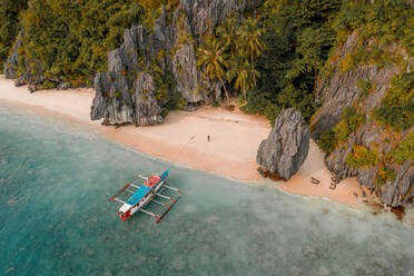 Luftaufnahme eines Ausleger-Fischerboots am Sandstrand, El Nido, Philippinen. - AAEF11258