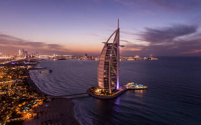 Aerial view of Burj Al Arab luxury hotel at sunset with cityscape facing the Persian gulf sea in background, Dubai, United Arab Emirates. - AAEF11269