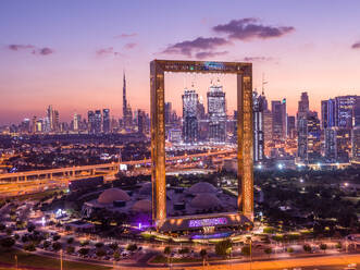 Aerial view of Dubai Frame, an iconic building in Dubai downtown with city skyline in background during a beautiful sunset, United Arab Emirates. - AAEF11270