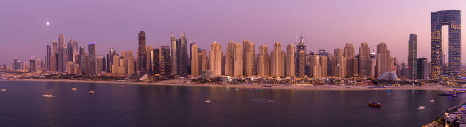 Panoramic aerial view of Dubai marina skyline with tall skyscrapers facing the creek at sunset, Dubai, United Arab Emirates. - AAEF11273