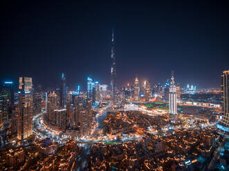 Aerial view of Dubai skyline with Burj Khalifa world's tallest skyscraper at night with Dubai creek in foreground, United Arab Emirates. - AAEF11279