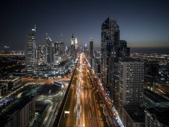 Luftaufnahme der Sheikh Zayed Road im Stadtzentrum von Dubai, einer viel befahrenen und großen Verkehrsstraße in der Innenstadt von Dubai, die zwischen hohen Wolkenkratzern bei Nacht verläuft, Dubai, Vereinigte Arabische Emirate. - AAEF11284