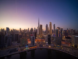 Luftaufnahme des Stadtzentrums von Dubai mit dem Burj Khalifa, dem höchsten Wolkenkratzer der Welt, und der Skyline der Stadt im Hintergrund bei Sonnenuntergang, Dubai, Vereinigte Arabische Emirate. - AAEF11285