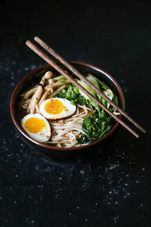 Draufsicht auf eine Keramikschüssel mit leckeren Ramen und Essstäbchen auf dem Tisch - ADSF27835