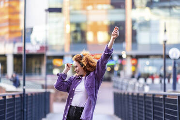 Young woman dancing on bridge during sunset - WPEF05068