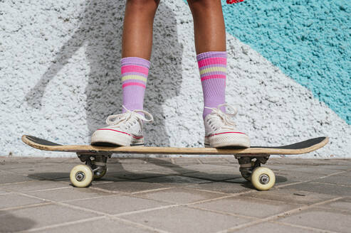 Girl standing on skateboard - JCMF02156
