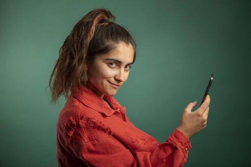 Smiling woman holding smart phone - AXHF00252