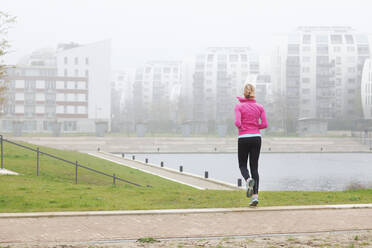 Frau trainiert beim Joggen im Park - FVDF00418