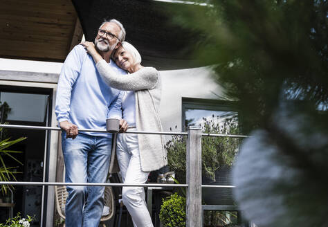 Woman standing with arm around of man at balcony - UUF24130