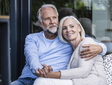 Mature couple holding hands while sitting at balcony - UUF24146