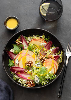 Von oben bunter leckerer Salat mit Endivien, Apfel und Roquefortkäse auf dunklem Hintergrund - ADSF28195