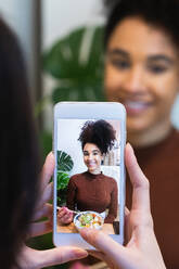 Unbekannte Frau fotografiert schwarzen Freund, der in einem Restaurant ein leckeres Poke-Gericht isst - ADSF28269