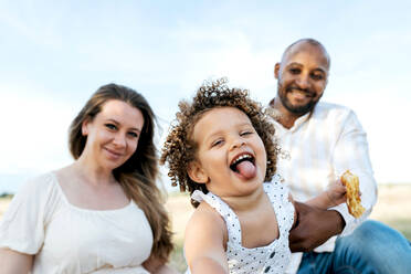 Glückliche multiethnische Familie mit süßer kleiner Tochter genießt Sommerpicknick in der Natur - ADSF28357
