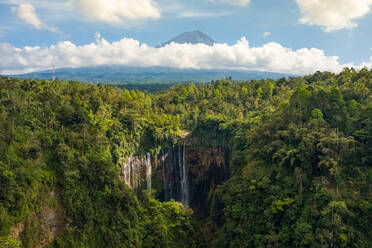 Luftaufnahme des Tumpak Sewu Wasserfalls in Java, Indonesien mit dem Vulkan Semeru im Hintergrund. - AAEF11463