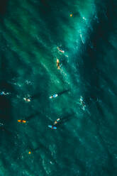 Aerial view of people surfing the waves in the ocean near Sakoneta beach in Gipuzkoa, Euskadi, Spain. - AAEF11493