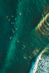 Aerial view of people surfing the waves in the ocean near Sakoneta beach in Gipuzkoa, Euskadi, Spain. - AAEF11495