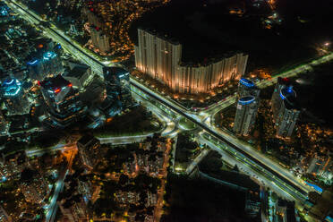 Luftaufnahme eines hohen Wolkenkratzers in Gurugram in der Nähe der Autobahn und der Bahnlinie bei Nacht. Bundesstaat Haryana während der Abriegelung, Indien. - AAEF11685