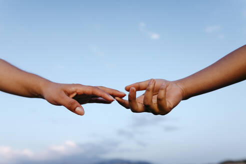 Female friends reaching towards each other - TCEF02036