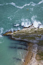 Luftaufnahme von zwei Personen beim Kajakfahren entlang der Küste in der Nähe von Durdle Door, West Lulworth, Dorset, Vereinigtes Königreich. - AAEF11837