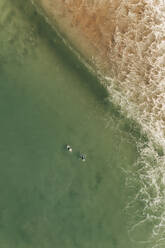 Luftaufnahme von zwei Surfern auf einer Welle im Meer bei Bedruthan Steps, Carnewas, St Eval, Cornwall, Vereinigtes Königreich. - AAEF11863