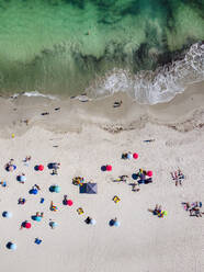 Luftaufnahme von Menschen, die sich unter dem Sonnenschirm am Clifton Beach im Sommer entspannen, Kapstadt, Südafrika. - AAEF12032