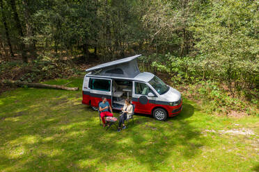 Aerial view of two people having lunch and camping next to their motorhome. - AAEF12137