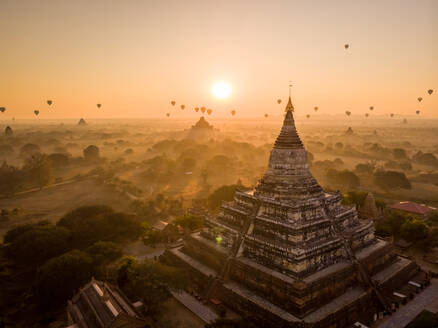 Luftaufnahme der buddhistischen Shwesandaw-Pagode, historische Stätte mit Heißluftballons im Hintergrund bei Sonnenuntergang, Nyaung-U, Myanmar. - AAEF12149