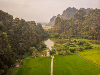 Luftaufnahme der Mahar-Sedan-Höhlen mit einem kleinen See im Vordergrund an einem nebligen Tag in der Gemeinde Hpa-an, Myanmar. - AAEF12180