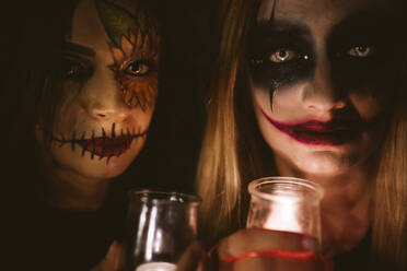 Frauen mit Halloween-Make-up halten beleuchtete Geräte - EGHF00118