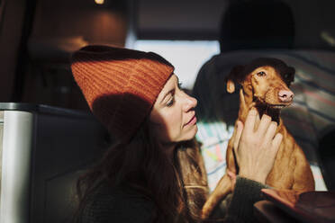 Woman looking at dog in van - MRRF01281