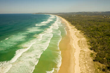 Luftaufnahme des Cosy Corner Beach, eines paradiesischen Strandes mit Meereswellen, die auf den Sand in Byron Bay, New South Wales, Australien, schlagen, - AAEF12245