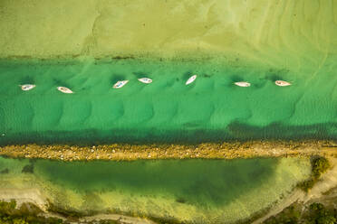 Aerial view of a few small sailing boat in the green water of Currambene creek near Huskisson, New South Wales, Australia. - AAEF12247