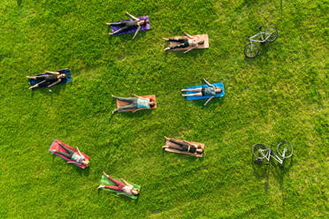 Aerial view of yoga group exercising in park. - AAEF12384