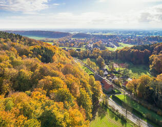 Luftaufnahme des Dorfes Brochterbeck und Herbstwald auf Hügeln, Tecklenburg, Teutoburger Wald, Nordrhein-Westfalen, Deutschland - AAEF12395
