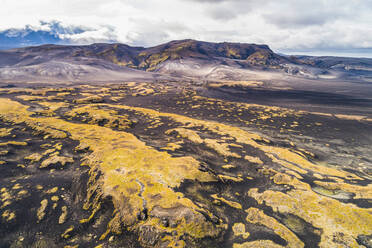 Aerial view of hilly lava field covered with mosses in front of Hekla volcano in the clouds, Iceland - AAEF12411