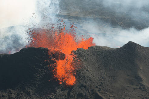 Luftaufnahme von Lava, die während des größten Vulkanausbruchs in Island seit 1784 über den Rand eines Kraters springt, aufgenommen im September 2014 von einem Hubschrauber aus, Holuhraun, Hochland von Island - AAEF12423