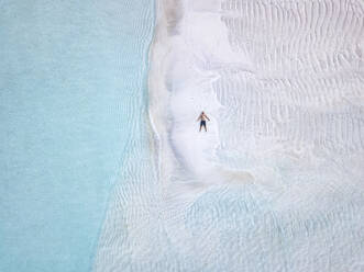 Luftaufnahme eines einsamen Mannes beim Sonnenbaden am Sandstrand der Insel Thulusdhoo - KNTF06288