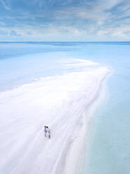 Luftaufnahme eines jungen Paares, das zusammen am Sandstrand der Insel Thulusdhoo steht - KNTF06295