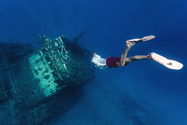 Mann schwimmt auf beschädigtes Schiff unter Wasser zu - KNTF06344