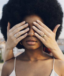 Junge Frau bedeckt die Augen ihrer Afro-Freundin - JCCMF03337