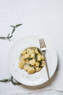 Teller mit verzehrfertigen italienischen Gnocchi-Knödeln mit geriebenem Parmesan - SBDF04506