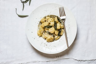 Teller mit verzehrfertigen italienischen Gnocchi-Knödeln mit geriebenem Parmesan - SBDF04508